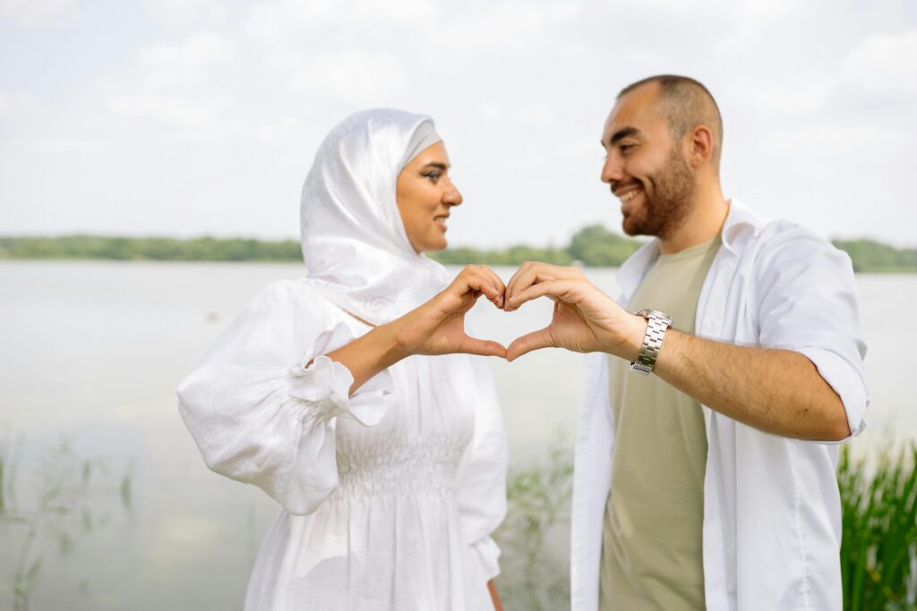 Wazifa For Love Couple sharing a romantic moment outdoors, forming a heart with their hands.